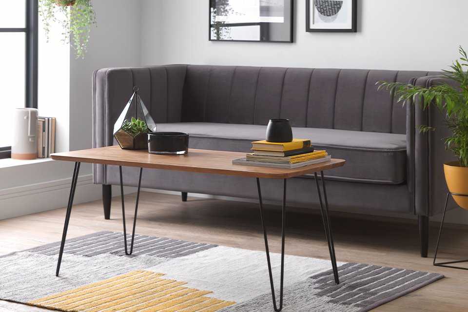 Living room with grey sofa, coffee table and rug.